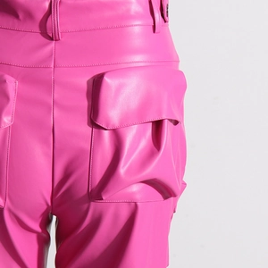 Dettaglio dei pantaloni cargo in ecopelle rosa con vita alta e ampia tasca laterale