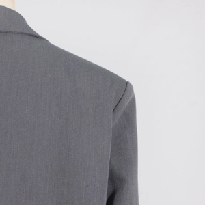 Gros plan de l'épaule structurée et de la couture sur une veste de blazer gris foncé