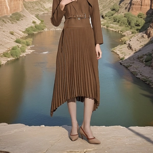 Detail of high-waist pleated skirt with metal eyelet belt and asymmetrical hemline
