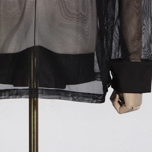 Vue détaillée du blazer en maille transparente avec poignets à boutons élégants