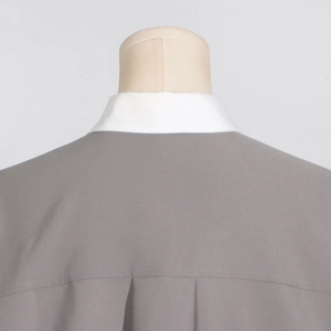 Detail view of the gray top featuring back pleat design and contrasting white shirt collar