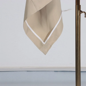 Detailed macro view of khaki trench coat hem featuring elegant white contrast piping detail