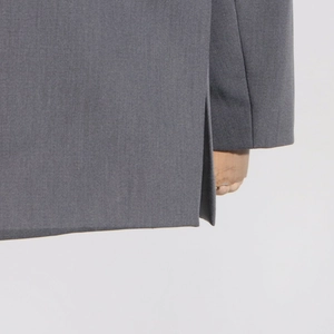 Détail de la fente arrière et de la texture tissée du tissu de ce blazer gris chic