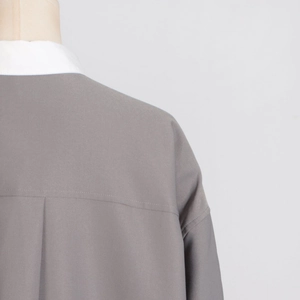 Macro view of grey casual top featuring a white turnover collar and back pleat detail