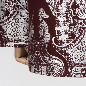 Détails de l'imprimé paisley argenté sur le tissu en velours bordeaux de luxe
