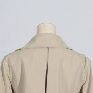 Detail view of the back collar and stitching on a beige urban slim fit trench coat