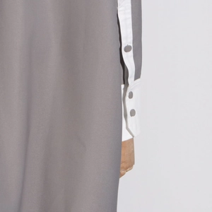 Close-up of contrast white cuffs and grey fabric with matching round buttons