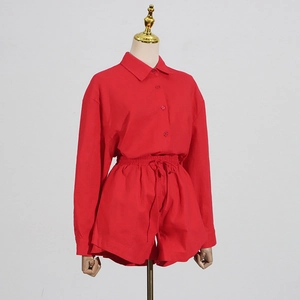 Detail view of red button-down shirt and matching drawstring shorts on a mannequin