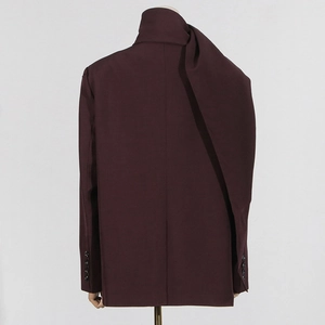 Detail of burgundy suit jacket featuring a draped scarf-like shawl collar and smooth fabric