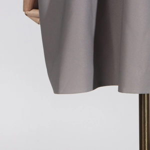Detail shot of the gray casual jacket hem showing smooth woven fabric texture and stitching