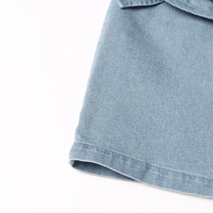 Gedetailleerde macro-opname van lichtblauwe denim stof met dubbel stiksel