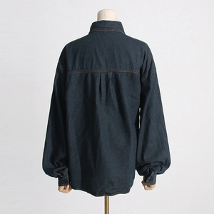 Dettaglio della giacca di jeans blu scuro con piega posteriore e cuciture rinforzate