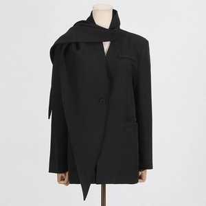 Detail of loose black blazer with asymmetrical scarf collar and single button closure