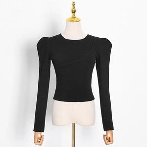 Detail view of black long sleeve top with puff sleeves and asymmetric diagonal seam lines