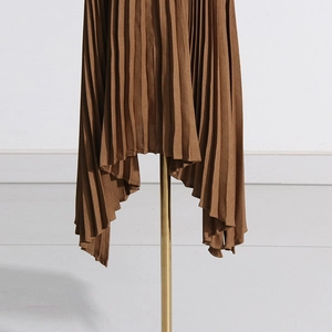 Detailed view of the irregular pleated hemline on a brown high-waisted midi skirt