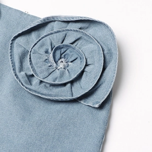 Detailopname van een 3D denim roos met rafelranden op een lichtblauwe A-lijn rok
