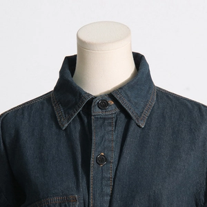 Dettaglio giacca in denim blu scuro con cuciture a contrasto e bottoni neri