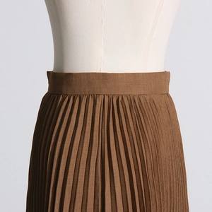 Detailed view of brown pleated skirt showing high waist design and vertical pleats