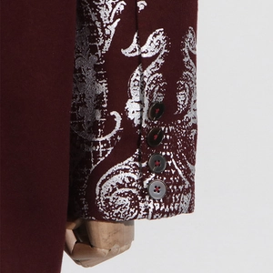 Détail du jacquard damassé argenté sur manche de costume bordeaux avec quatre boutons et couture