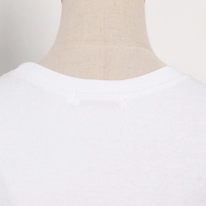 Detailed macro view of white ribbed knit fabric and crew neckline on long sleeve top