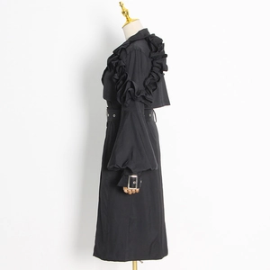 Detailed view of elegant black trench dress featuring layered ruffles and lantern sleeves