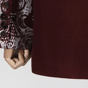 Détail de la manche de blazer bordeaux avec broderies argentées et quatre boutons élégants