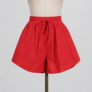 Detail view of red high-waisted wide-leg shorts with elastic drawstring waistband