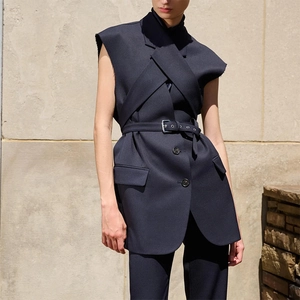 Close-up of sleeveless suit vest showing lapel detail, waist belt, and frayed edge finish