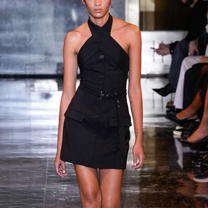 Detail of elegant black halter neck dress with waist belt and double pockets