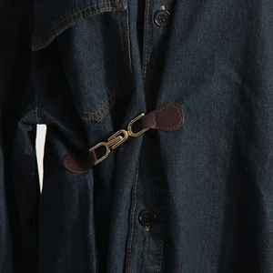 Dettaglio giacca di jeans blu scuro con fibbia dorata e cinturino in pelle fine