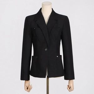 Détail d'un blazer noir cintré avec clous argentés sur le revers et les poches pour le bureau