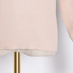 Close-up of pink ribbed knit sweater texture on a mannequin with golden base