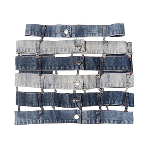 Detail of multi-layer spliced denim mini skirt with metal buttons and patchwork design