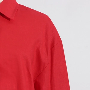 Detailed macro view of the red linen texture fabric on the collar and shoulder seams
