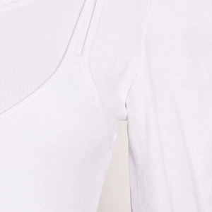 Detail of white ribbed knit fabric texture and shoulder strap stitching on long sleeve top