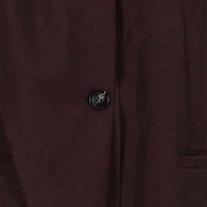 Close-up of a marbled button and welt pocket on a burgundy loose-fit casual blazer
