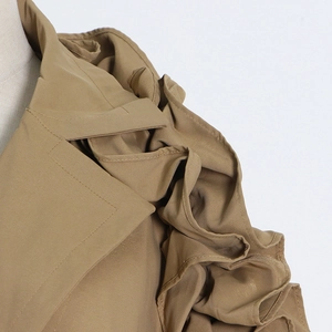 Detail of layered ruffle shoulder stitching on khaki trench coat with premium tailoring