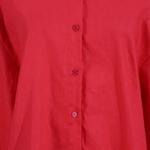 Detail of red linen shirt placket featuring matching buttons and natural woven texture