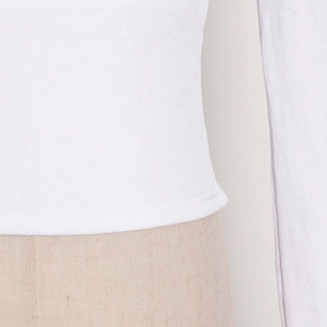 Detailed macro view of the white ribbed fabric and neat double-needle hem stitching