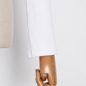 Detailed close-up of ribbed knit texture and stitching on long sleeve white T-shirt cuff