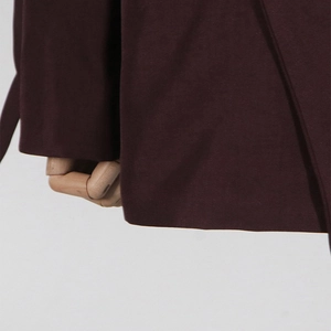 Detailed macro view of deep burgundy blazer fabric texture on a mannequin hand