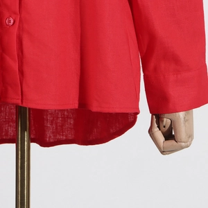 Detail view of red cotton linen shirt with matching buttons and curved hemline