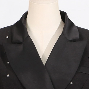 Detail of satin lapel and crystal rhinestone embellishments on a black suit jacket