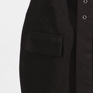 Detail view of the black dress featuring a flap pocket and silver metal eyelets accents