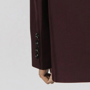 Close-up of four black buttons on the cuff of a deep burgundy wool blazer jacket