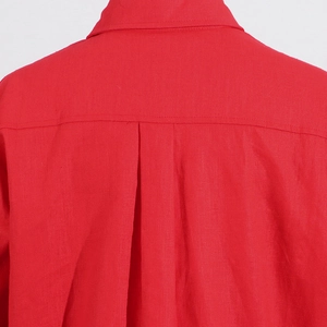 Detail of red cotton shirt back with central box pleat and yoke seam texture