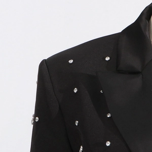 Detail of satin lapel and sparkling rhinestone embellishments on a black suit jacket