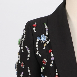 Close-up of luxury black blazer with handmade colorful rhinestones and white pearls on collar