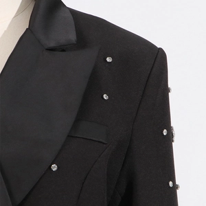 Detail of black blazer with satin lapel and scattered silver rhinestones on texture
