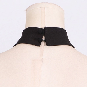 Detail of the back neck closure with dual fabric-covered buttons on a black halter dress